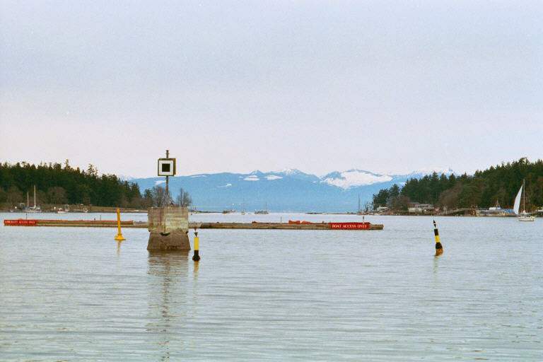 Day Beacons & Cardinal Buoys: The Cardinal Buoy to the right with the top marks pointing outward is an 'East' buoy indicating that safe water is to the east of the mark. The square on the concrete is a port hand day beacon. In the background is Nanaimo harbour.